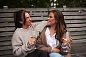 Smiling female friends relaxing in garden