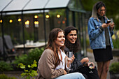 Smiling friends sitting in garden