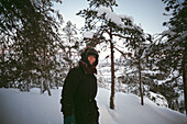 Teenager mit Pelzmütze in einer Winterlandschaft