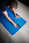 Man using cell phone on fitness mat
