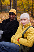 Two friends in park in autumn scenery