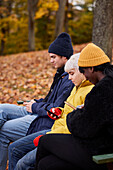 Drei Freunde im Park mit Smartphones