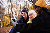 Three friends in park using smartphone