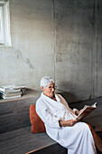Ältere Frau liest eine Zeitschrift