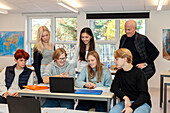 Teenager und Lehrerin mit Laptop im Klassenzimmer