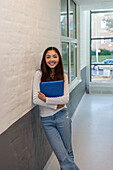 Portrait of teenage girl standing on school corridor