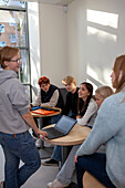 Teenagers using laptop on school corridor