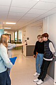 Teenage kids using phone on school corridor