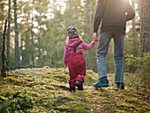 Eltern gehen mit ihrer kleinen Tochter spazieren