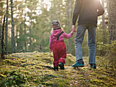 Parent walking with toddler daughter