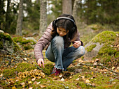Girl wearing headphones in forest