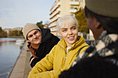 Lächelnde junge Freunde unterhalten sich im Freien