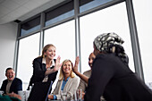 Women giving high five to each other during business meeting
