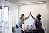 Geschäftsleute, die sich während einer Besprechung im Büro die Hände reichen