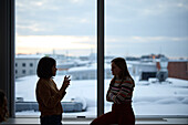 Women standing against window and talking