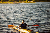 Man in yellow kayak holding oar