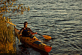 Man kayaking on sunny autumn day