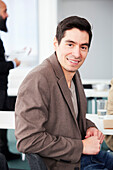 Portrait of young businessman sitting at desk