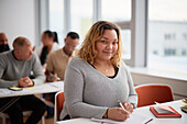 Portrait of woman making notes in class