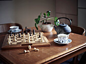 Tea cups and chess board on table