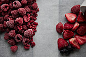 Piles of raspberries and strawberries on table