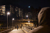 People on footbridge at night