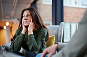 Mature woman holding head in hands