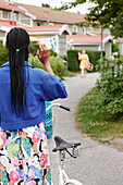 Rückansicht einer Frau, die neben einem Fahrrad steht