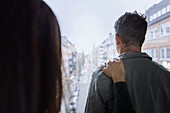 Woman touching man's arm by window