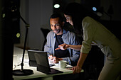 Man and woman working late in office