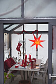 Red Christmas star and decorations on table