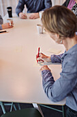 Frau macht Notizen während eines Meetings