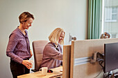 Smiling women talking in office