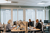 Smiling women using computers in office