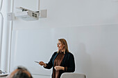 Lächelnde Frau bei einer Präsentation in einer Besprechung