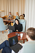 Smiling woman using laptop at work