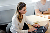 Woman using laptop during business meeting