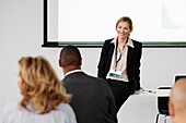 Business people sitting and listening to businesswoman