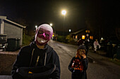 Children wearing Halloween costumes posing at night