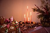 Angezündete Kerzen und Weihnachtsschmuck