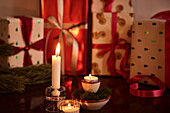 Christmas presents and candles on table