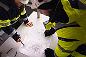 Ingenieure prüfen Pläne auf der Baustelle
