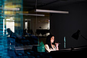 Young businesswoman working in office at night