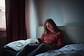 Man on bed using cell phone