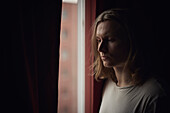 Thoughtful man looking through window