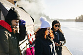 Smiling friends standing at lake