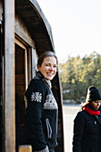 Lächelnde Frau vor der Sauna stehend