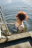 Woman swimming in cold lake