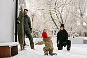 Happy family at winter outside house