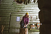 Frau hackt Holz im Schuppen